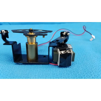Black and brass rotary solenoid aperture diaphragm with central cylinder mounted on black bracket for topcon fundus camera