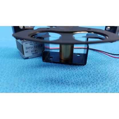 Black rotary solenoid aperture diaphragm switch with metallic center labeled sap1 t1158 on silver base for topcon camera