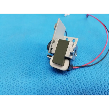 Silver metal rotary solenoid filter shutter with black white components and red black wiring for topcon fundus camera