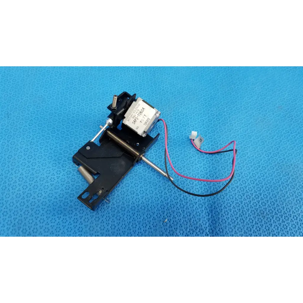 Black plastic and metal internal takano rotary solenoid mechanical switch with silver label and pink and black wires