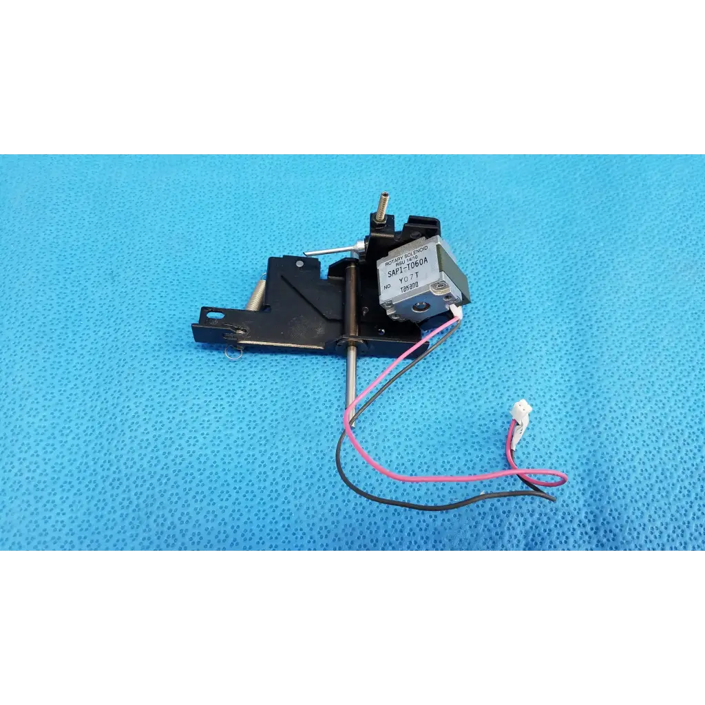 Black plastic and metal rotary solenoid mechanical switch with pink and black wires labeled sap1-t3r0a for topcon retinal camera