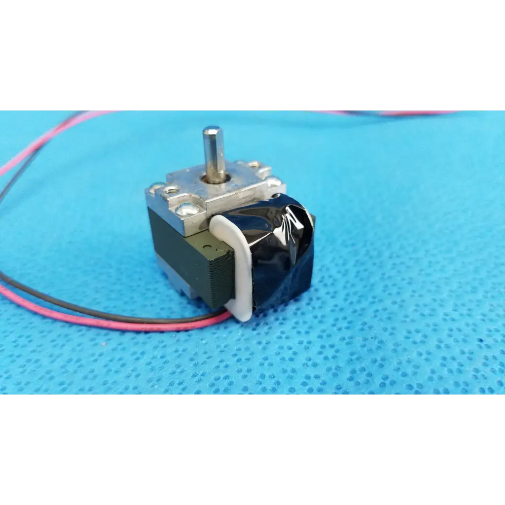Black and silver stepper motor with metallic shaft and exposed wiring for internal Takano rotary solenoid used in fundus retinal camera