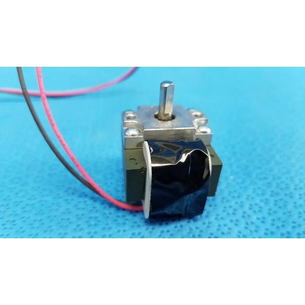 Silver metal rotary solenoid with black wrapped component and pink gray wires for topcon fundus retinal camera