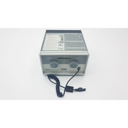 Silver metallic ivac core calibrator 900 with two circular dials, coiled black power cord, and printed instructions on top