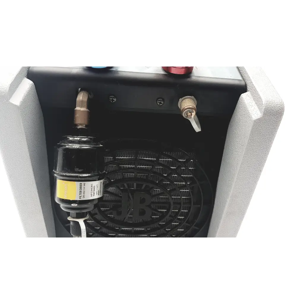 Jb industries f6-dp piston refrigerant recovery unit with black cylindrical filter housing and metallic fittings inside gray casing