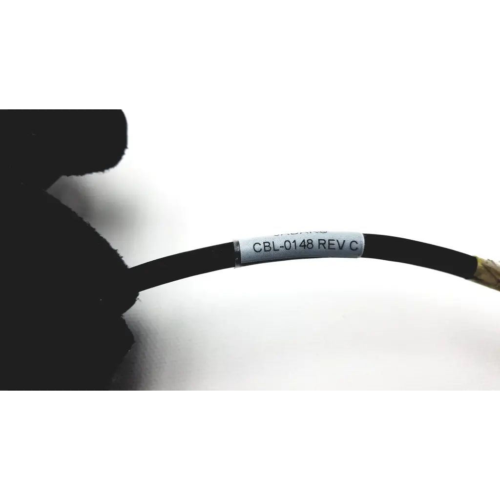 Black coiled cable with a silver label cbl-0148 rev c and gold connector for jadak barcode scanner jdk-1799 rev a