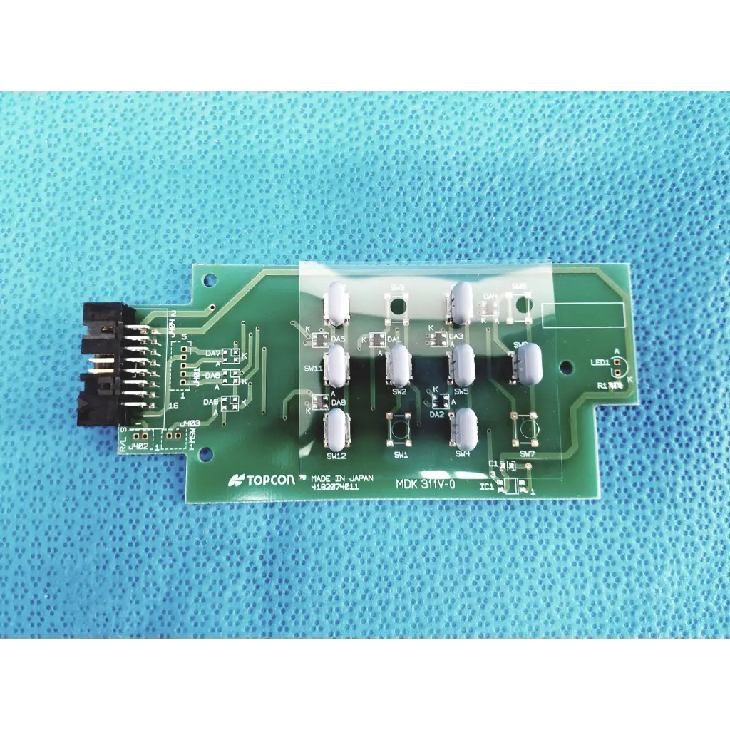 Green pcb board with white cylindrical components and black connector labeled topcon mdk 31iv-0 for fundus retinal camera