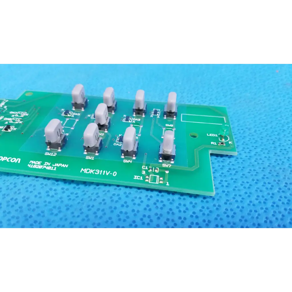 Green printed circuit board with eight gray toggle switches for joystick base control in topcon retinal camera