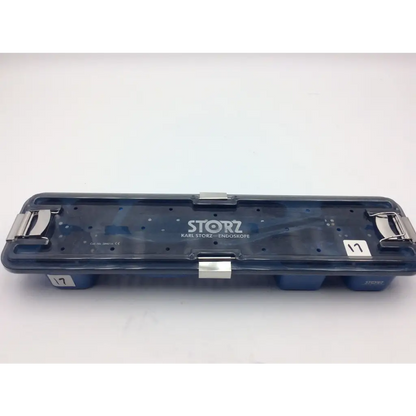 Dark blue translucent plastic karl storz flexible scope sterilization tray with silver metal latches and white label on lid