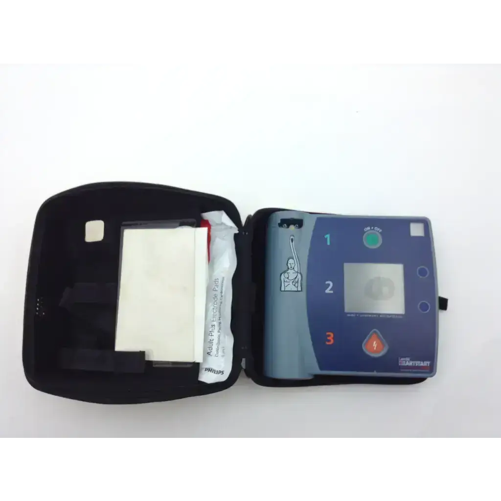 Blue and gray laerdal heartstart fr2 aed with black carrying case open showing pads battery and data card tray