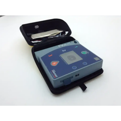 Blue and gray laerdal heartstart fr2 defibrillator device in black carrying case with pads battery and data card tray