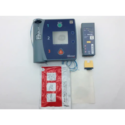 Blue and gray laerdal heartstart fr2 automated external defibrillator with battery electrode pads and adhesive strips
