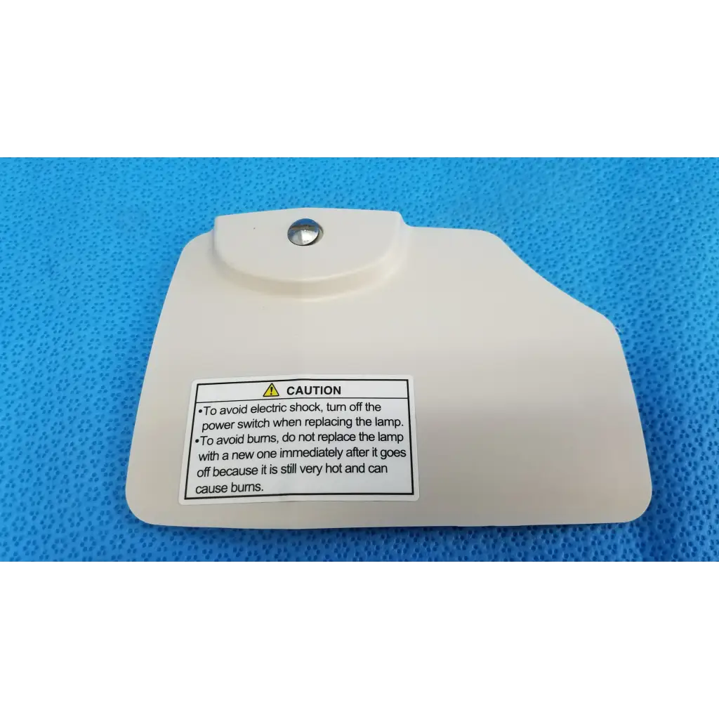 Off-white plastic lamp house cover panel with silver screw and caution label for Topcon TRC-NW8 retinal camera