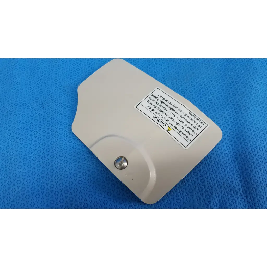 Beige plastic lamp house cover panel with silver screw and warning label for Topcon TRC-NW8 retinal camera lamp house