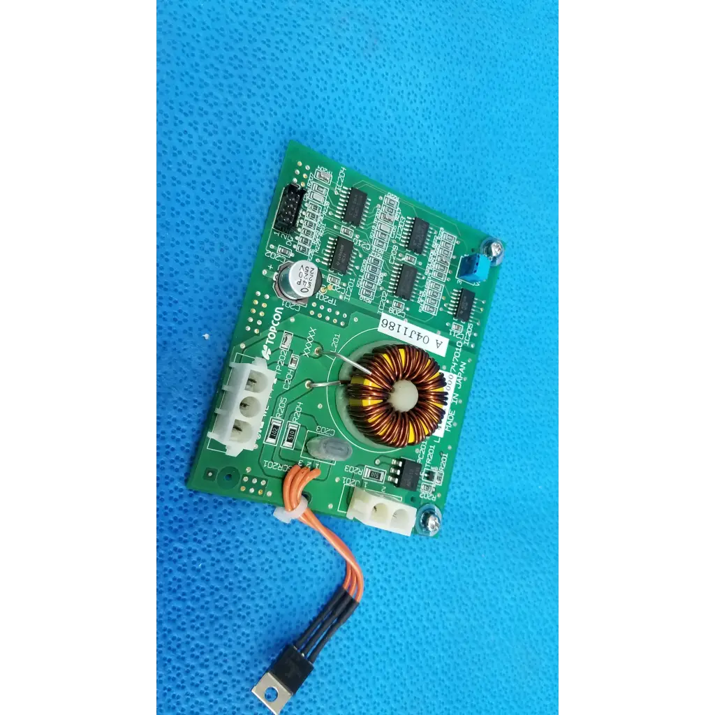 Green illumination circuit board with black ICs, toroidal inductor, white connectors, and orange-black cable for Topcon camera