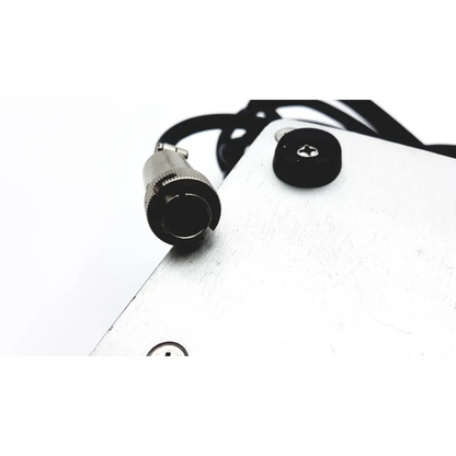 Silver metallic connector with black rubber grip and threaded collar attached to white panel on linemaster switch corporation claasic iv foot switch