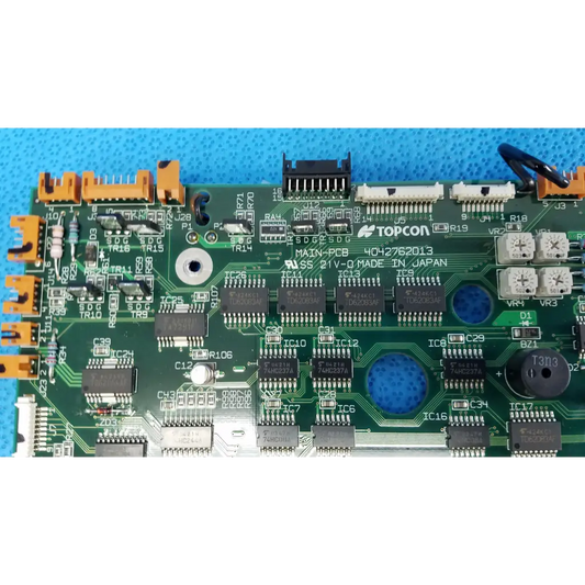 Green motherboard circuit board with black integrated circuits and orange connectors for topcon retinal camera