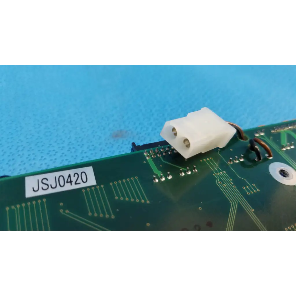 White plastic connector with two metallic pins on green motherboard circuit board for topcon trc-nw6s retinal camera