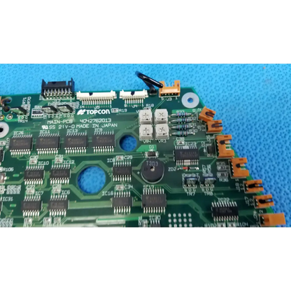 Green motherboard circuit board with black and orange connectors and silver capacitors for Topcon retinal camera