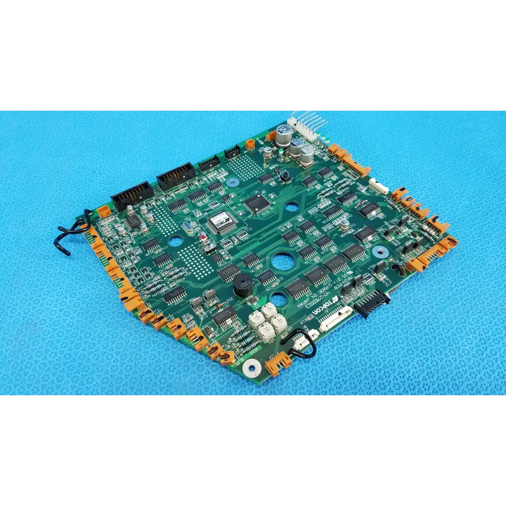 Green motherboard circuit board with black integrated circuits and orange connectors for Topcon TRC-NW6S retinal camera