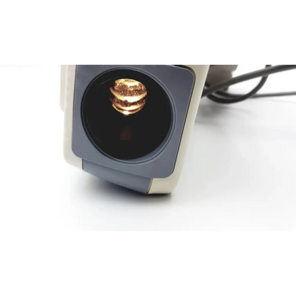 A golden layered burger-shaped object inside the circular aperture of the marco cp-690 auto chart projector scanner