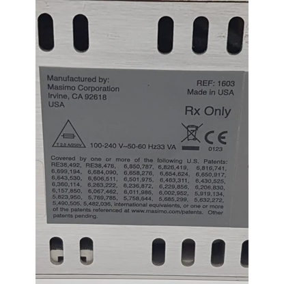 Gray rectangular label with black text on the back of masimo 1603 signal extraction pulse oximeter rad 9 showing manufacturer details and regulatory markings