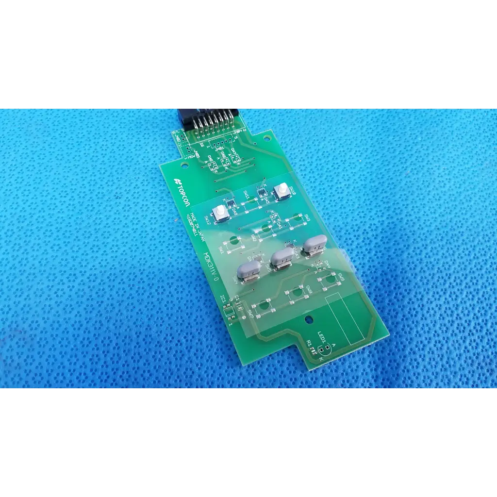 Green printed circuit board with silver components and black connector for mdK311V-0 control panel button switch