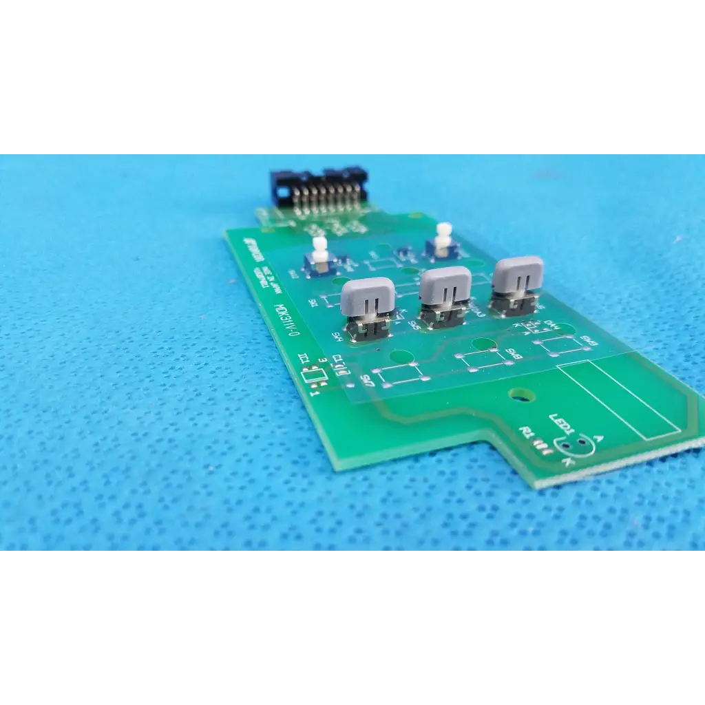 Green printed circuit board with gray and black electronic components for control panel button switch mdK311V-0