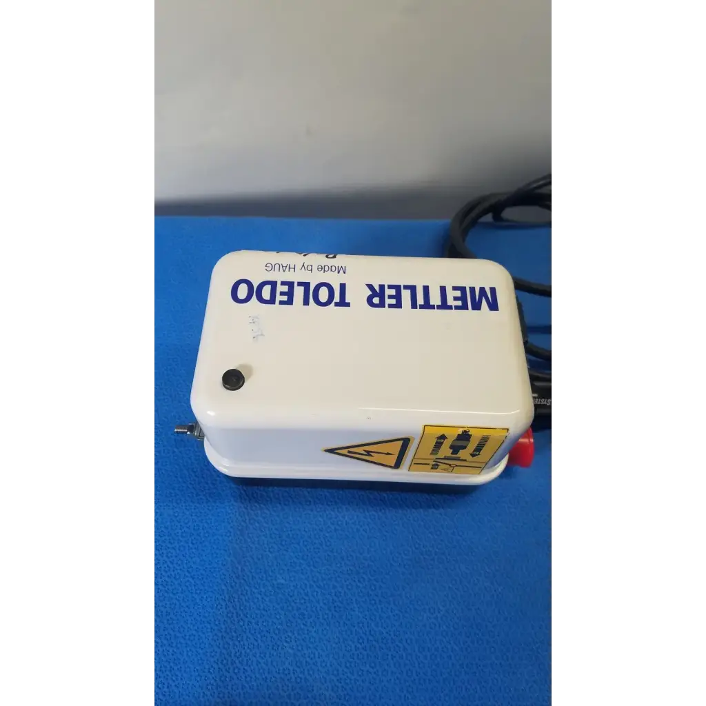 White plastic mettler toledo haug static eliminator bar ionizing power supply with blue lettering and yellow warning label