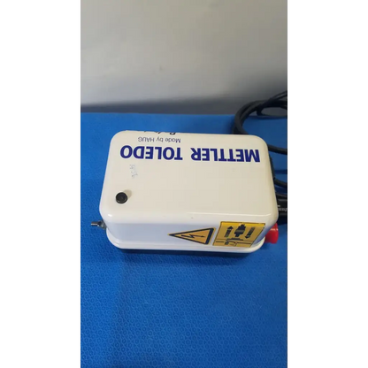 White plastic mettler toledo haug static eliminator bar ionizing power supply with blue lettering and yellow warning label
