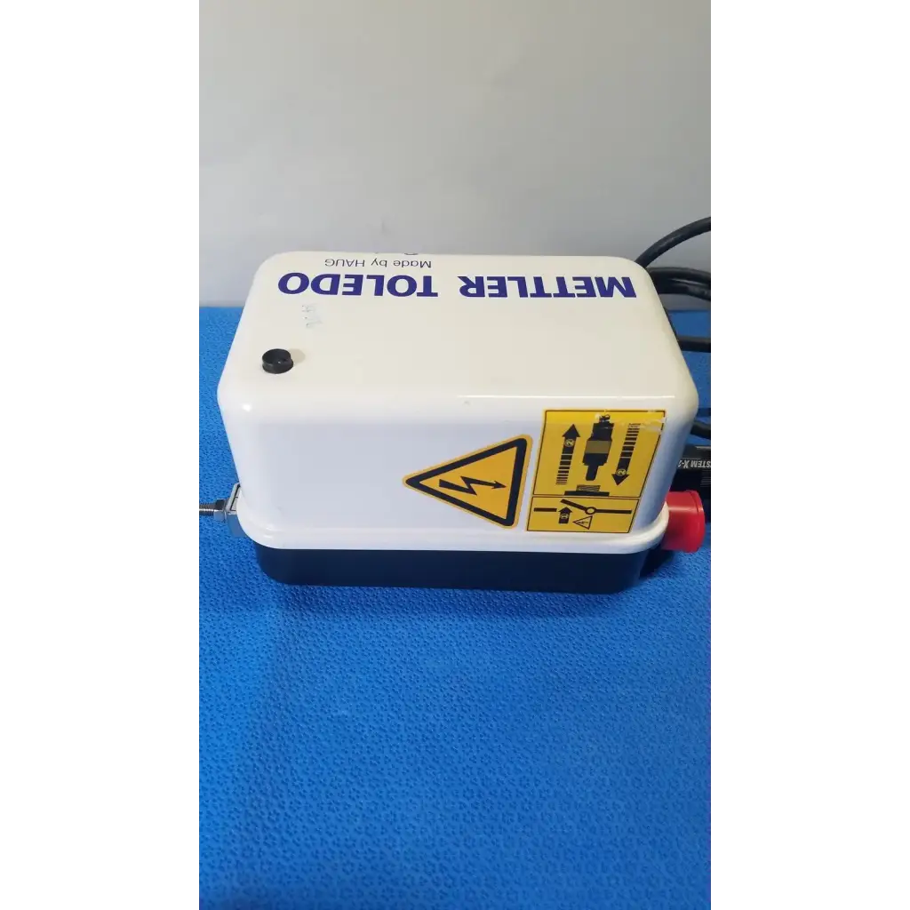 White and black mettler toledo electronic pump with red valve and safety labels for haug static eliminator power supply