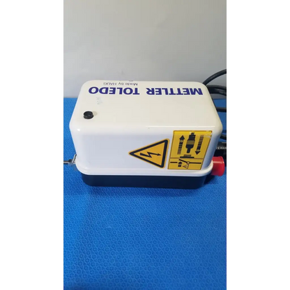 White and black mettler toledo electronic pump with red valve and safety labels for haug static eliminator power supply