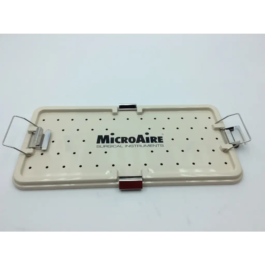 Cream-colored plastic surgical instrument tray with black perforated holes and metal clamps from micro aire surgical instruments
