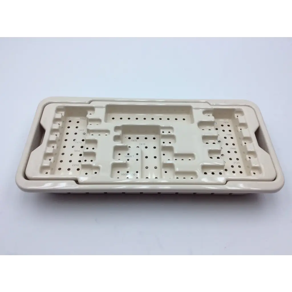 Cream-colored ceramic surgical instrument tray with molded compartments and perforated sections for micro aire surgical instruments