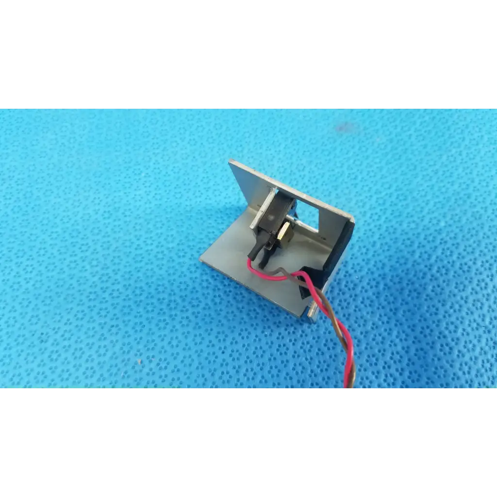 Silver metallic electromagnetic lock with red and black wiring for microswitch limit sensor bracket assembly on retinal camera