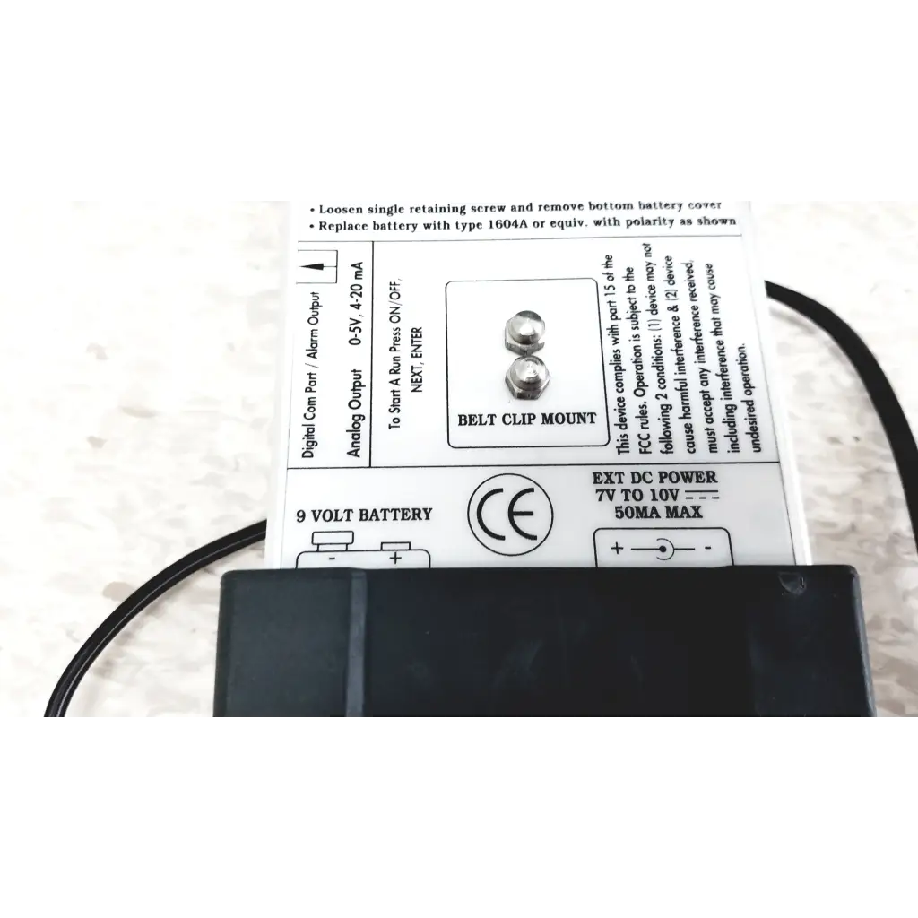 Backside of black plastic belt clip mount with silver screws and battery label for mie personal aerosol monitor industrial hygiene