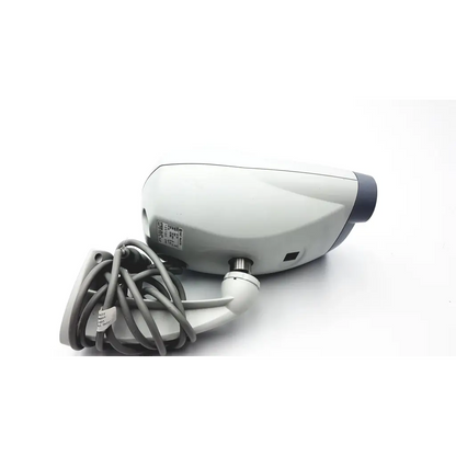 Gray and white dome security camera with coiled gray cable attached to the wall mount of nidek cp-770 chart projector