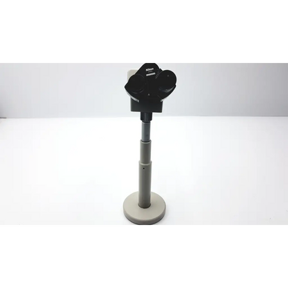 Black Nikon 030039 binocular microscope with stereo lenses mounted on a gray adjustable stand for precision use