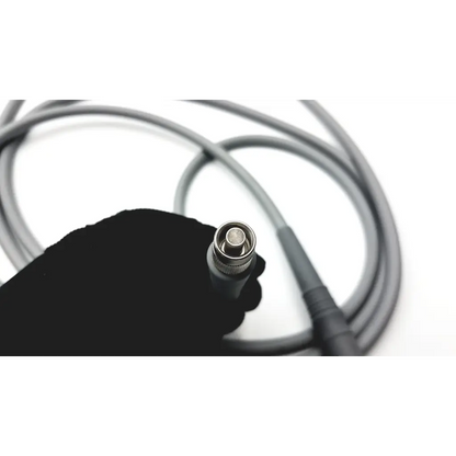 Gray olympus autoclavable fiber optic light cable with metallic bnc connector held in gloved hand for medical use