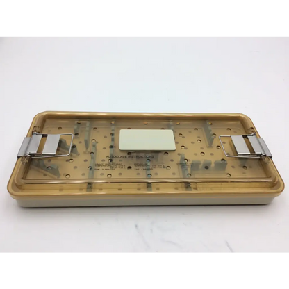 Beige plastic olympus autoclave instrument tray with metallic clamps and central label for sterilizing tools