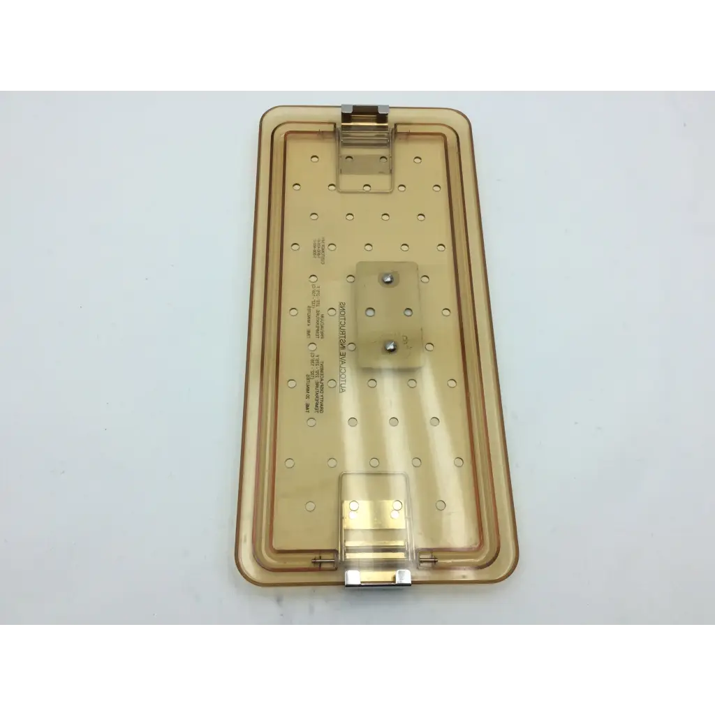 Transparent amber-colored plastic olympus autoclave instrument tray with hinged lid and circular indentations for sterilization
