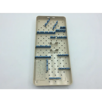 Beige plastic olympus autoclave instrument tray with blue and metallic components in organized slots for sterilization