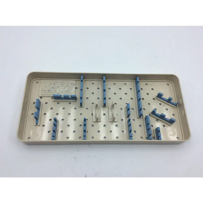 Beige plastic olympus autoclave instrument tray with blue and silver metal holders for surgical instruments