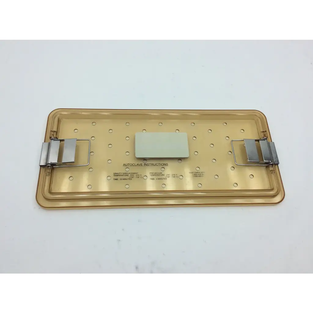 Translucent gold-colored plastic olympus autoclave instrument tray with metal clamps and white label for sterilization use
