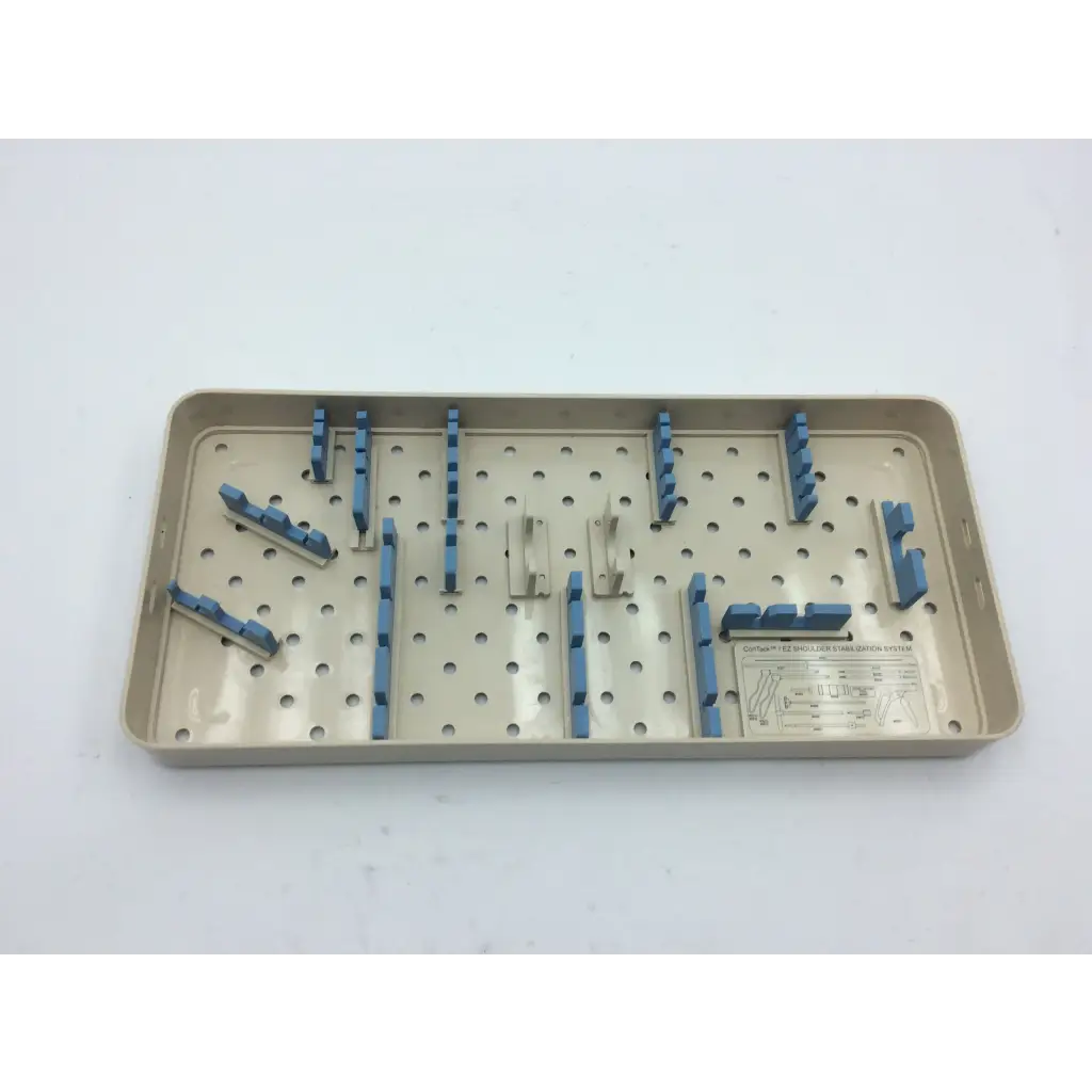 Beige plastic olympus autoclave instrument tray with blue and silver metal clamps arranged in a grid pattern