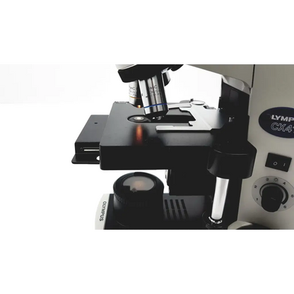 Black and silver olympus cx41rf microscope with rotating stage, objective lenses, and focus knobs for lab use