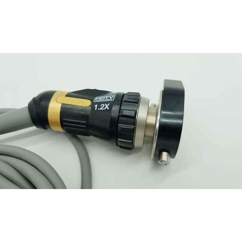 Black and gold autoclavable camera head with 1.2x magnifying lens textured grip and metallic connector attached to gray cable