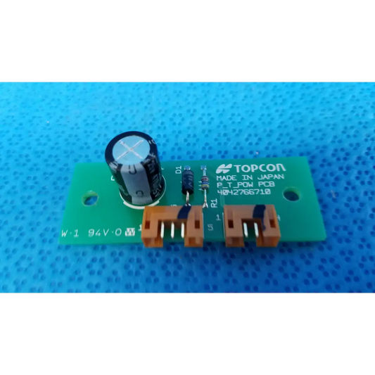 Green rectangular power circuit board with black capacitor and orange connectors labeled topcon p_t_pow pcb for retinal camera
