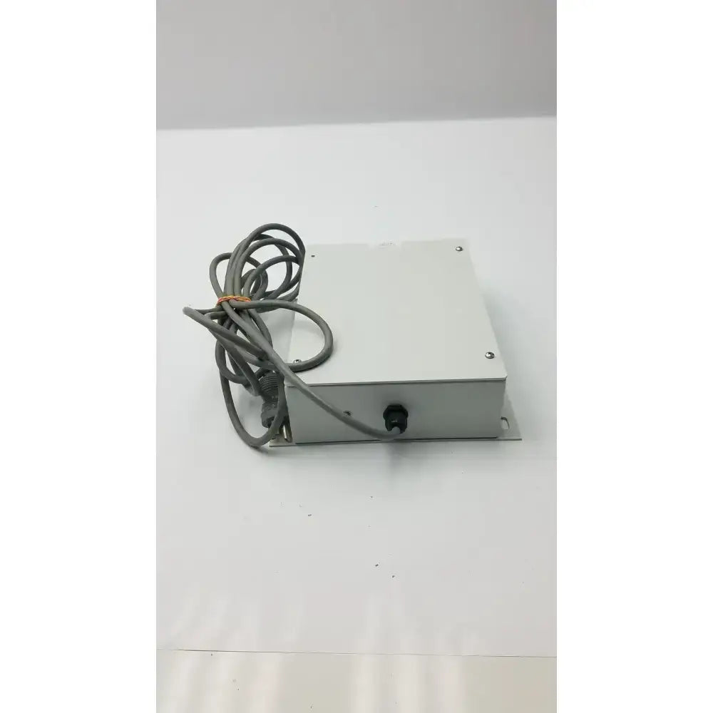 Silver metallic rectangular isolation transformer offset controller with coiled gray cable part no 11970-0000-01