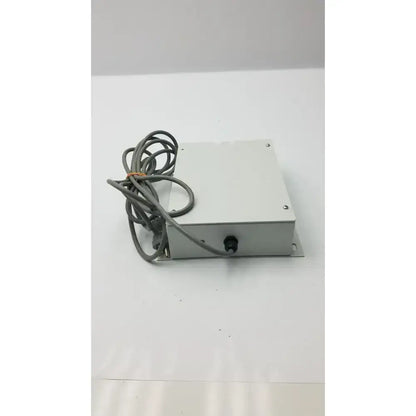 Silver metallic rectangular isolation transformer offset controller with coiled gray cable part no 11970-0000-01